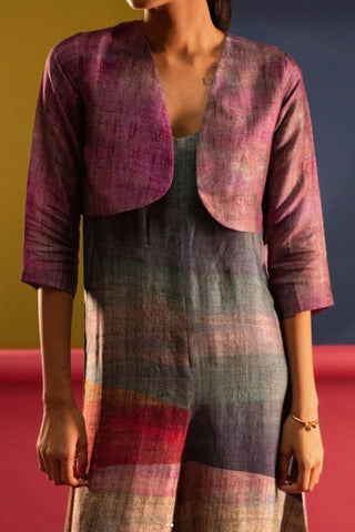 Woman wearing a multicolored dress with a matching jacket against a red and blue background. A close-up of a jumpsuit featuring a soft ombré colour gradient print.