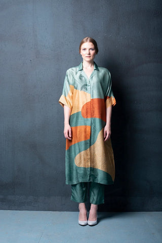 Two-piece Rusty green dupion silk set featuring geometric abstract print kurta with asymmetrical hemline and parallel pants. Perfect for brunch, evening gatherings and daytime wear. Designed by clos.