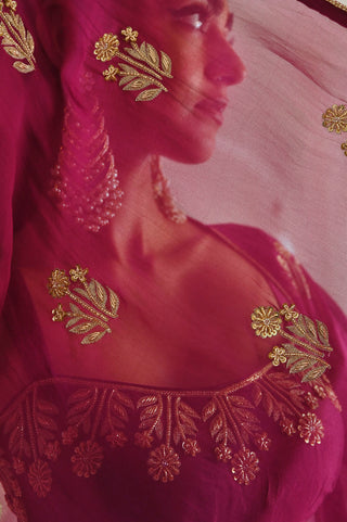 Contemporary Indian ethnic wear set in magenta — floral embroidery bralet, sheer embroidered jacket, and elegant cowl skirt for modern wedding styling.