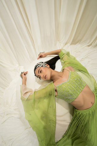 Close-up of lime bustier with delicate line embroidery paired with an embroidered jacket.