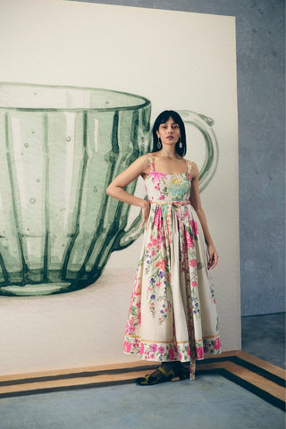 Designer off-white floral maxi dress featuring an artistic botanical print, fitted bodice, concealed side zip, and matching silk belt. This elegant full-length dress combines comfort and refined style for modern women's wardrobes.