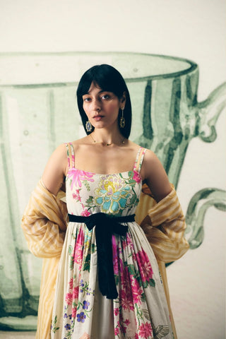 Hanami Off White Maxi Dress featuring elegant ivory floral prints, breathable poplin fabric, fitted bust, concealed side zip, and a modal silk tie-up belt. Perfect for summer occasions and elegant daytime wear.
