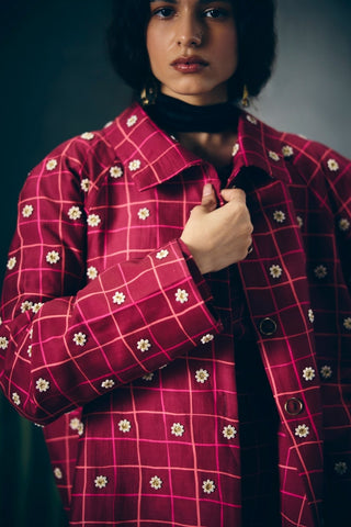 Elegant maroon checkered skirt paired with a detailed embroidered bustier and coordinating shirt. A refined outfit offering a polished look with contemporary styling for versatile occasions.