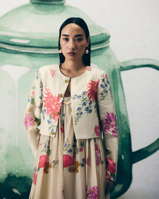 Woman in a statement ivory floral chic jumpsuit all set ready to go to a soiree evening friends wedding party.