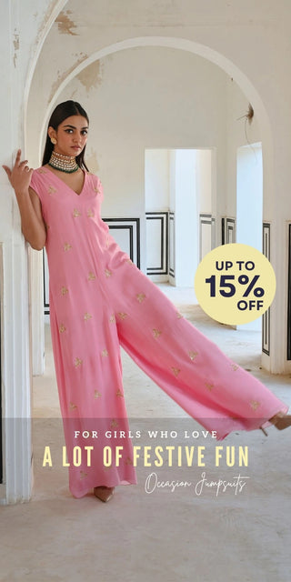 A model in pink jumpsuit posing in playful vibe in heavy jewellery. A Designer Fusion Jumpsuits perfect for Festive Occasion Wear.