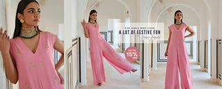 A model in pink jumpsuit posing in playful vibe in heavy jewellery. A Designer Fusion Jumpsuits perfect for Festive Occasion Wear.