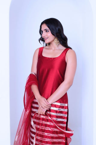 Close up of golden patti border on red silk sleeveless kurta set by Ghazal, detailed craftsmanship in women’s ethnic wear, perfect for festive outfits and wedding occasions.