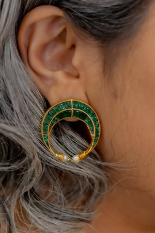Women wearing a green moon shaped stud earring for pairing with ethnic and indo-western outfits, and dresses. Antique gold plated look for classy and elegant look.