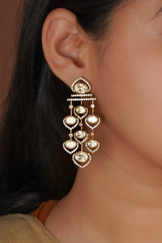women wearing classic white hues earring set designed with intricate detailing and gold finish, perfect for enhancing festive and wedding looks with a rich ethnic aesthetic.