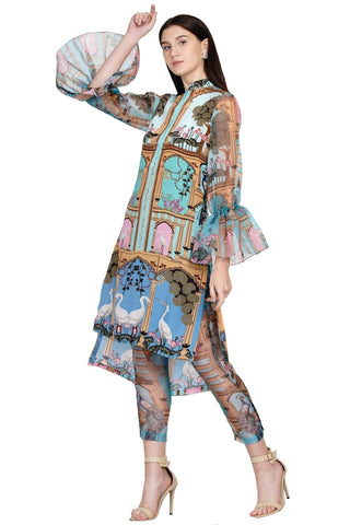 Bohemian Pichwai-printed asymmetrical tunic with embroidered detailing and sheer sleeves, styled with flowy printed sheer pants — perfect for travel diaries.