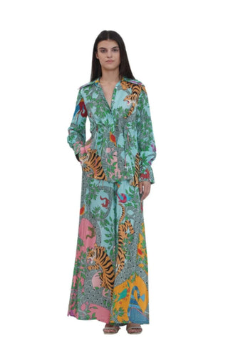 Front view of a resort-wear printed co-ord set for women, featuring a cinched-waist shirt with Gond-inspired placement prints, pearl embroidery, shell tassels, and matching flared trousers — perfect summer and vacation outfit. Designed by Limerick Indian Designer