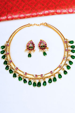 Gold hasli artificial necklace with green stones and matching earrings. Perfect for wedding ceremonies, bridal wear, special ocassions.