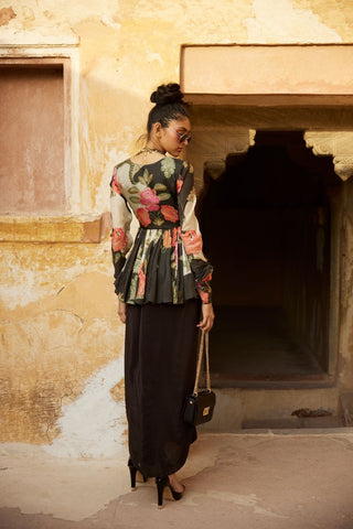 Back look of Modern floral silk peplum with pearl and zardosi embroidery, featuring tassel drawstring accents and a pre-draped black skirt for a chic fusion look.
