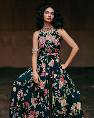 A Paulmi and Harsh models a sleeveless, black jumpsuit. An intricate floral print in pink, green, and beige. Perfect for Birthday Party bash, Welcome drinks, Friends catch-up brunch etc.