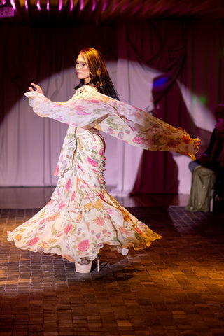 Flowing pallu of the saree captured mid-air in a dynamic side profile shot. chintz and bird printed pre-draped saree with belt and blouse in off-white colour, featured on the Australian Fashion Grandeur runway.
