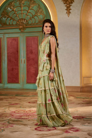 Elegant green pre-draped chiffon saree featuring tiered lace borders and handcrafted blouse embroidery, perfect for festive occasions.