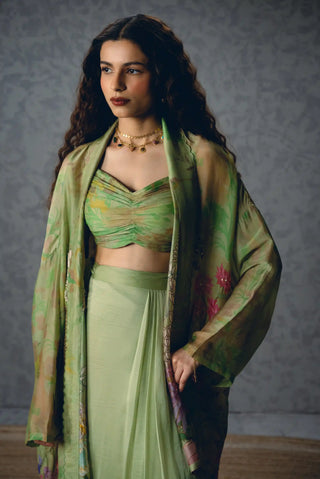 Cleo green skirt set blends a delicate floral organza jacket with a pleated fitted blouse and wrap skirt, offering sophisticated designer styling for dinners and evening occasions.