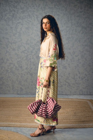 Luxury off-white satin outfit featuring a button-down shirt and coordinated wrap skirt with contemporary appeal.