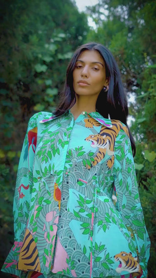 Video of a resort-style co-ord set featuring a cinched-waist printed shirt with pearl embroidery and shell tassels, paired with flared crepe trousers with placement prints and a side slit — a chic summer and holiday-ready outfit.