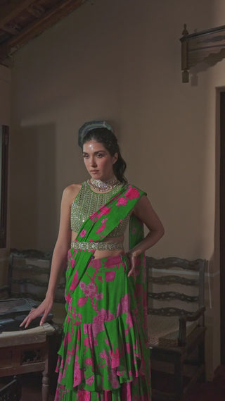 Model in blooming big floral green saree set, hit the sangeet dance floor, with three gorgeous layers for that perfect oomph. The halter–neck blouse has embellishments that emphasize its beauty. Designed by Paulmi and Harsh.
