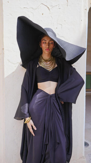 Model in Indo Western women's black skirt blouse jacket set also called Choga Set. Designed by Paulmi and Harsh. A 3 piece Co-ord set perfect for casual outing at brunches, beach, party, summer wear, formal events. 