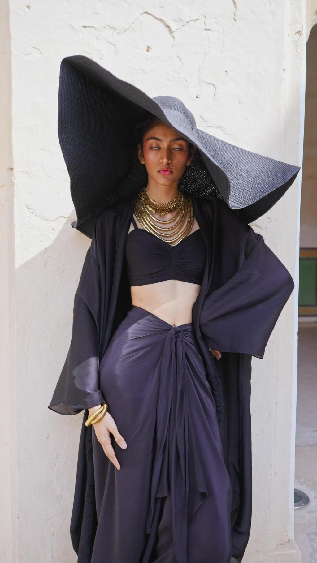 Model in Indo Western women's black skirt blouse jacket set also called Choga Set. Designed by Paulmi and Harsh. A 3 piece Co-ord set perfect for casual outing at brunches, beach, party, summer wear, formal events. 