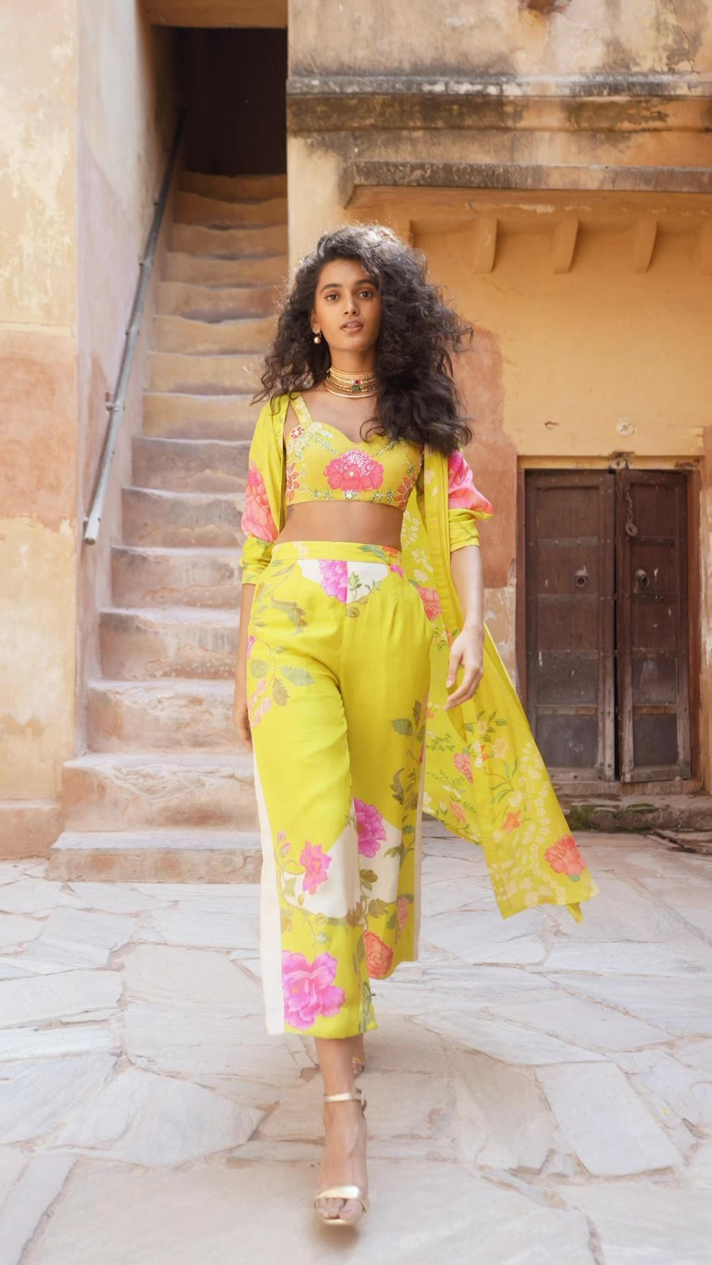 Model in lime yellow robe jacket set in a cheerful and fresh color combination. The blouse is hand-embroidered with delicate highlights, designed by Paulmi and Harsh.