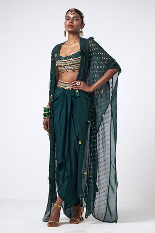 Elegant three-piece bottle green coord set with statement cape, hand embroidery, and scattered sequin detailing for occasion wear styling. Designed by Rishi and Vibhuti.
