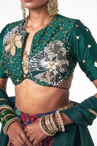 Designer emerald green blouse and lehenga set showcasing intricate handwork, decorative trims, and coordinated dupatta.