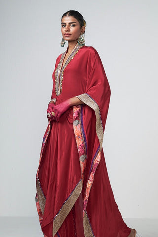 Model showcasing a cherry crepe kaftan set with handcrafted embroidery and crystal hanging details during a premium festive collection photoshoot.
