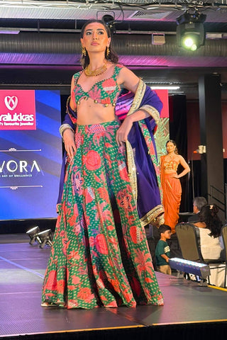 Model in jade green boho lehenga set posing for photoshoot at fashion runway in Australia. Crafted in crepe and organza fabric featuring intricate needlework, decorative trims, tassels, blouse, lehenga, and dupatta.