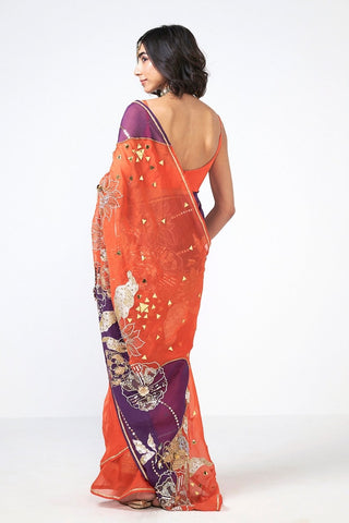 Back look of narangi saree set highlighting flowing silhouette and elegant handcrafted detailing.