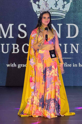 Elegant crepe and organza lehenga set with handcrafted embellishments, lace accents, and vibrant contemporary styling. Model wearing rishi vibhuti designed lehenga at a fashion runway.