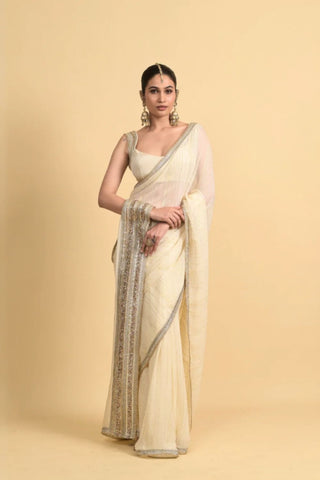 Designer ivory saree, Georgette & Chanderi Silk fabric, Linear trim golden embroidery on the border of the saree. Perfect for wedding and festive or special occasions.