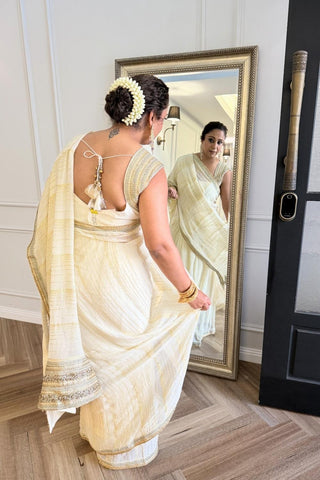 Designer ivory saree, Georgette & Chanderi Silk fabric, Linear trim golden embroidery on the border of the saree. Perfect for wedding and festive or special occasions.