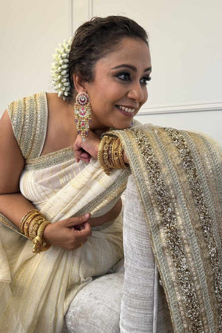 Designer ivory saree, Georgette & Chanderi Silk fabric, Linear trim golden embroidery on the border of the saree. Perfect for wedding and festive or special occasions.