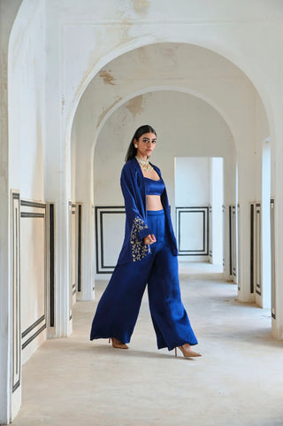 Side profile showing the palazzo and bralet styling underneath the loose-fitted blazer.