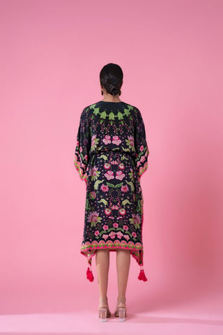 Back view of a midnight black ombre kaftan with an evenly blended gradient effect, showcasing the full fall of the fabric and pom-pom lace detailing around the hem