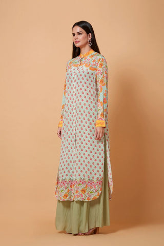 A stylish grey and orange shirt dress with a mandarin collar, layered over green pants to create a bold, modern silhouette with an Indo-western appeal.