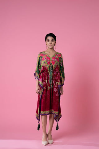 Scarlet red and kale green printed, embroidered kaftan featuring a floral print, and delicate pom-pom lace along the edges, V-shaped neckline, and a cinched waist with a pink tasseled rope belt. Perfect for resort wear, casual day out, seaside evenings. Designed by Siddhartha Bansal.